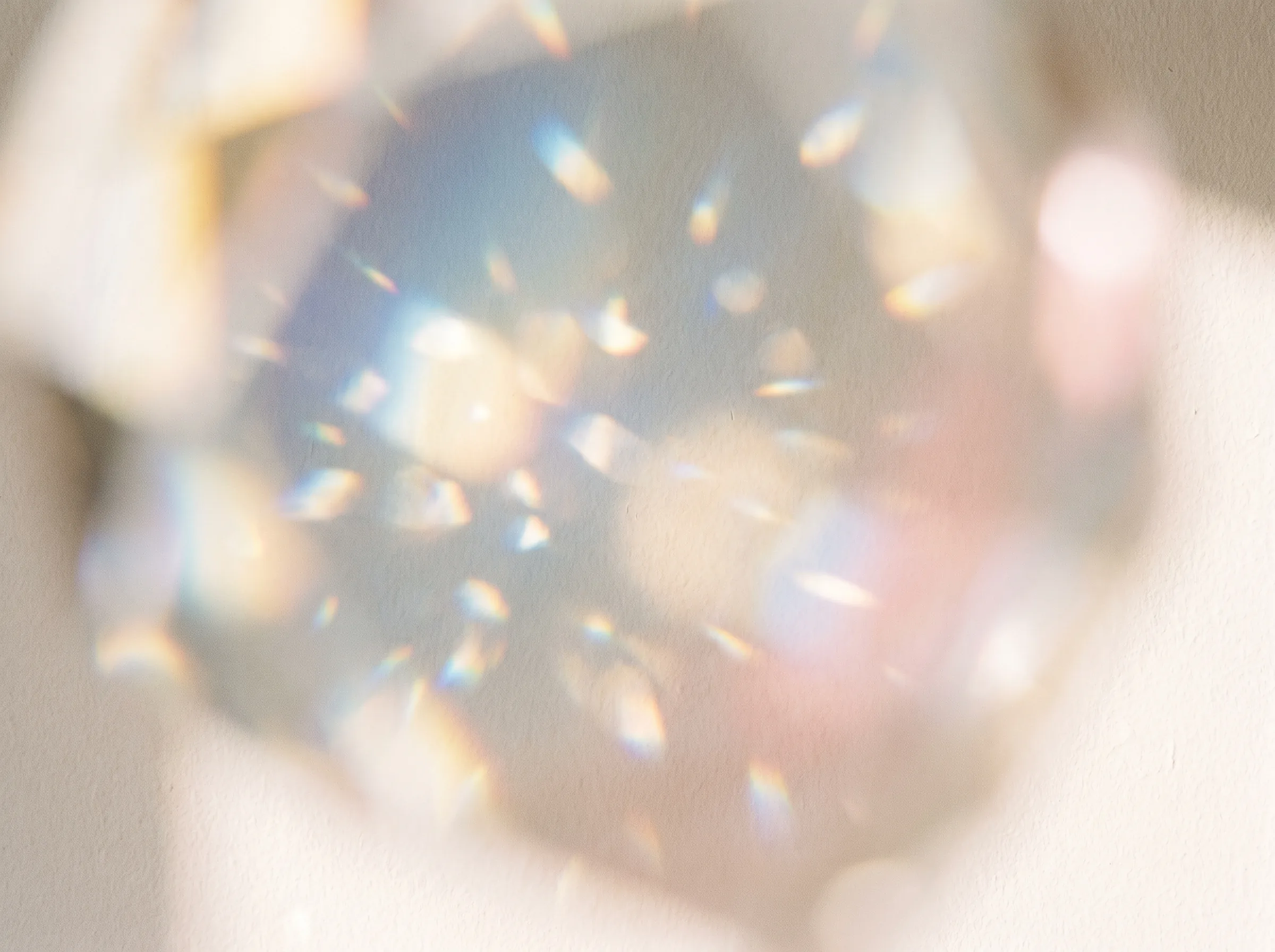 Soft prism of light scattered across a warm wall
